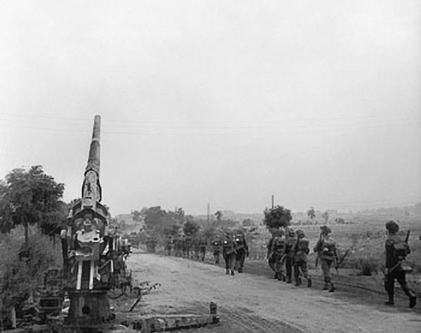 50 (Northumbrian) Division moving up past a knocked-out German 88mm gun
